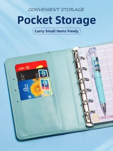 Detail of A7 binder with internal card slots, budget sheets, and matching pen