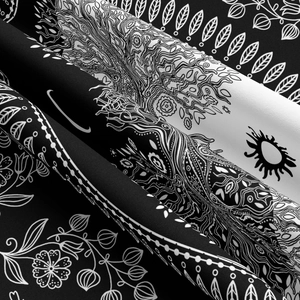 Macro shot of mandala patterns on black and white tapestry fabric with folded texture