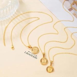 Close-up of three gold geometric necklaces with X Y Z initial pendants and measurements