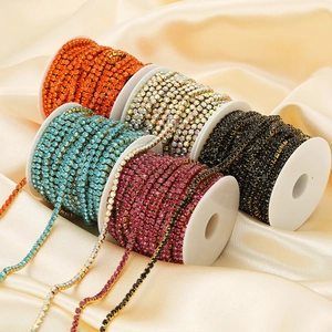 Five rolls of colorful rhinestone cup chains on spools for DIY jewelry and crafts