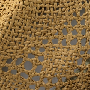 Close-up of natural raffia straw weaving texture and breathable hollow mesh detail