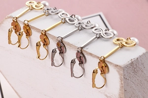 Macro shot of infinity symbol pearl drop earrings in gold and silver finish