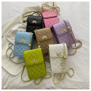 Macro view of metal twist lock and chain strap on quilted crossbody phone bag