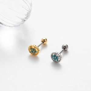 Detailed view of gold and silver flower stud earrings with vibrant blue stones