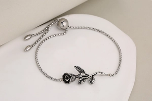 Macro detail of silver stainless steel rose charm and adjustable sliding clasp closure