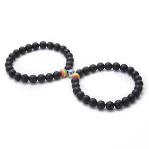 Magnetic couple bracelets with black matte stones and rainbow beads on white background