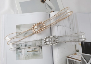 Detail of transparent PVC belts for women with pearl-encrusted gold and silver buckles