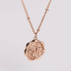 Macro shot of rose gold cherry blossom pendant with detailed floral embossing on thin chain