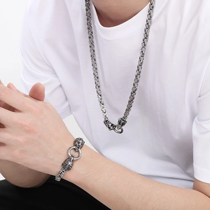 Detail of silver Byzantine chain necklace and bracelet set with lion head charms on a model