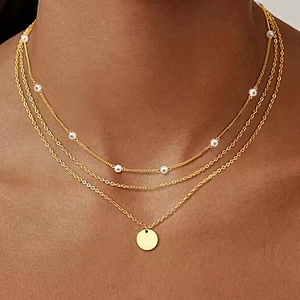 Three-layer gold necklace with pearls and a round pendant for women layered style