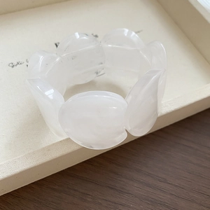 Detailed view of white translucent acrylic petal-shaped links on a stylish bracelet