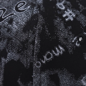 Macro view of twill weave fabric and graffiti-style print on a black hip-hop cap