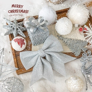 Noeuds argentés scintillants et boules de Noël blanches sur bois rustique et neige