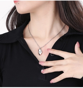 Detail shot of irregular silver crescent moon necklace on a model with black clothing