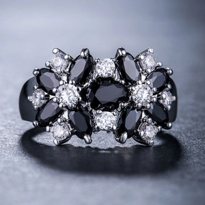 Dettaglio macro di anello floreale con pietre marquise nere e zirconi bianchi