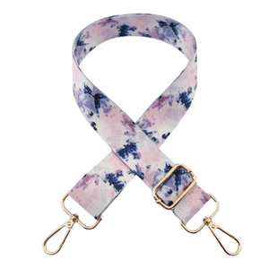 Dettaglio della tracolla in tela tie-dye colorata con ganci e fibbie in metallo dorato