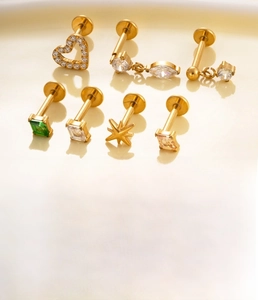 Detailed view of titanium alloy studs with zircon in heart and star shapes in gold and silver