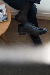 Detail of premium black mid-calf business socks featuring breathable silk texture and high elasticity