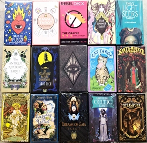 Flat lay of multiple themed tarot and oracle card decks displayed on a light surface