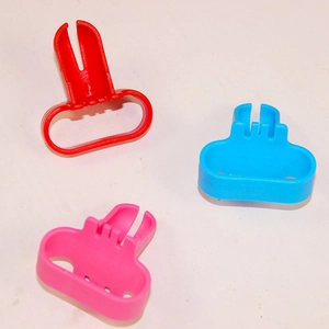 Close-up of plastic balloon knotting tools in red, blue, and pink for party supplies