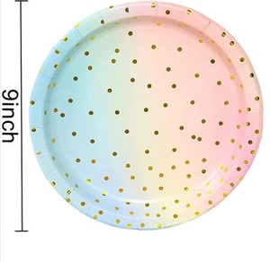 Detail of a 9-inch disposable round paper plate with rainbow gradient and gold polka dots