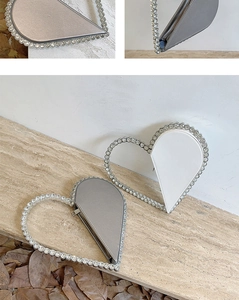 Close-up of heart-shaped evening bag featuring rhinestone-studded frame and zipper detail