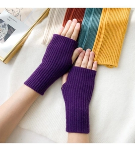 Macro detail of purple knitted fingerless gloves with a classic ribbed texture