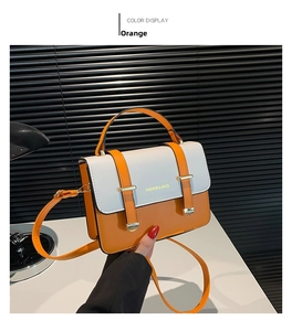 Detail of color-block crossbody bag in orange and grey with golden buckle and handle