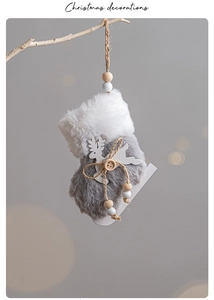Detail of plush Christmas stocking ornament with wooden deer and hanging rope decor