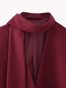 Detail of the elegant burgundy wool coat featuring a stylish scarf-style wrap collar design