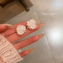 Close-up detail of handcrafted white sequin flower earrings with elegant bead center