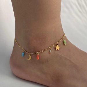 Gold stainless steel anklet with moon star charms and colorful beads on woman ankle