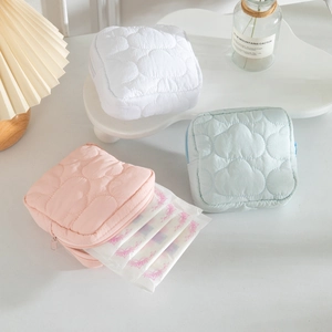Macro view of cloud-patterned quilted storage pouches in pink, white, and blue colors