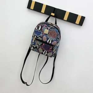 Detail of colorful snakeskin pattern on a mini backpack with gold hardware accents