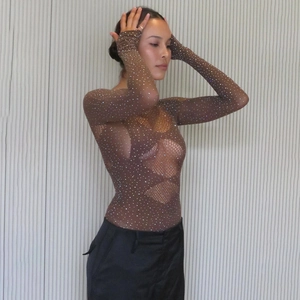 Détail d'un body en maille transparente avec strass brillants et découpe poitrine