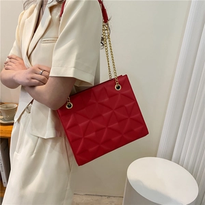 Detailed view of red quilted PU leather crossbody bag with elegant gold chain strap