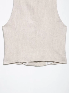 Close-up of oatmeal linen vest back hem showing natural woven texture and stitching detail