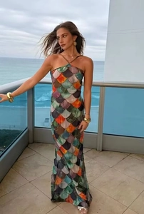 Detail of slim fit maxi dress featuring colorful mermaid scale print on an ocean view balcony