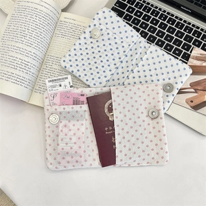 Detail of polka dot passport holder interior showing multi-functional card slots and metal clasp
