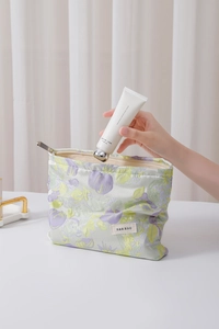 Detail view of floral makeup bag featuring H&R BAG logo and jacquard flower pattern