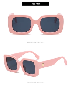 Close-up of pink square sunglasses with golden metal rivets and dark UV lenses