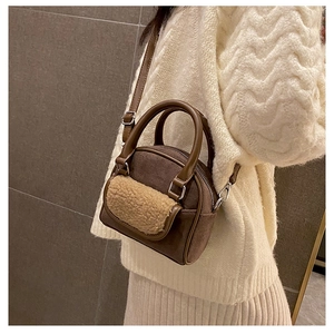 Brown suede crossbody bag with fleece pocket detail styled on a knit sweater outfit