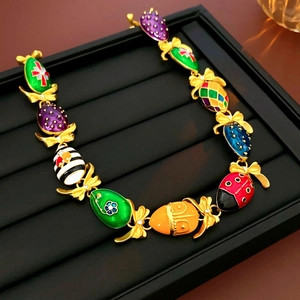 Dettaglio della collana vintage dorata con uova in smalto colorato e fiocchi
