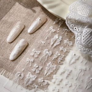 Elegant white 3D bow nail art stickers with lace patterns and pearl finish on nails