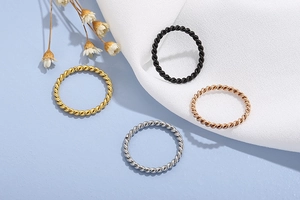 Detail of twisted rope rings in gold, black, silver, and rose gold stainless steel