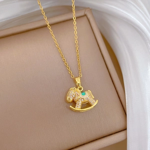 Detail of gold-plated rocking horse pendant with rhinestones on brown leather box