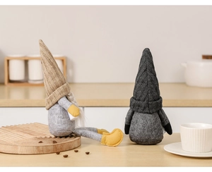 Detail of knit gnome plush figurines with heart pattern hats in a warm kitchen setting