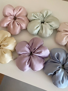 Close-up of silk flower hair scrunchies in soft Morandi colors with satin finish
