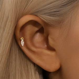 Close-up of a 925 sterling silver gold heart stud earring with zircon on a model's ear