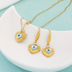 Detailed view of 18k gold plated heart devil eye necklace and earrings set on a tray